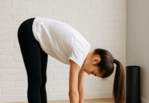 Teen girl doing a forward fold stretch on a yoga mat before the SAT exam