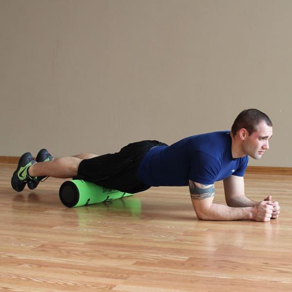 Foam rolling exercises for sore legs with an athlete wearing athletic clothing during a recovery workout session.