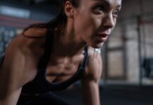 Close-up of a determined female athlete sweating during a workout session indoors.