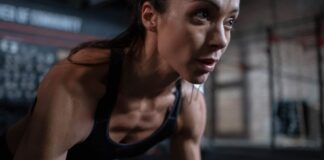Close-up of a determined female athlete sweating during a workout session indoors.