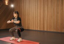 safe exercise after surgery for beginners Young woman exercises indoors with resistance band on mat for fitness