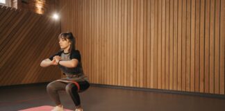 safe exercise after surgery for beginners Young woman exercises indoors with resistance band on mat for fitness